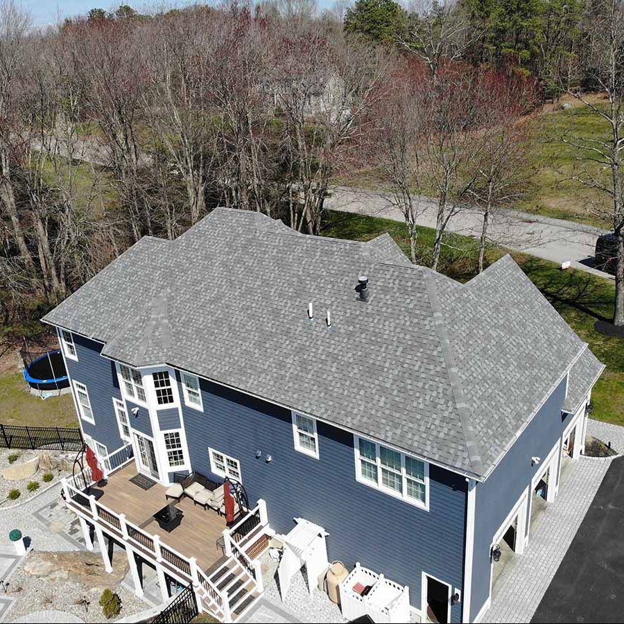 An aerial view of Atlas Roofing Shingles on a house with a body of water in the background. Atlas Roofing Shingles - CertainTeed vs. Atlas Shingles - January 2023 Blog Post (3)