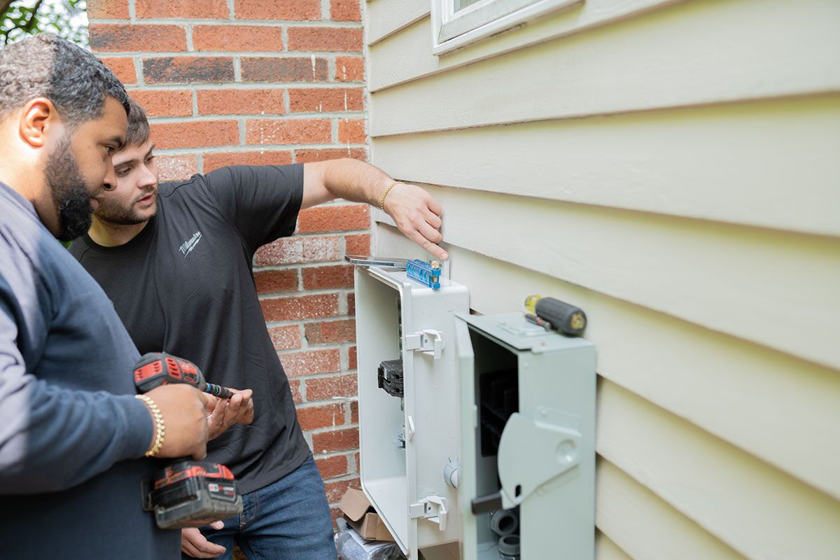 The Golden Group Solar team working on solar panel installation on the side of a house.
