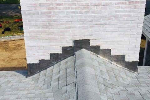 Exterior view of a chimney on a roof that has some flashing leak damage