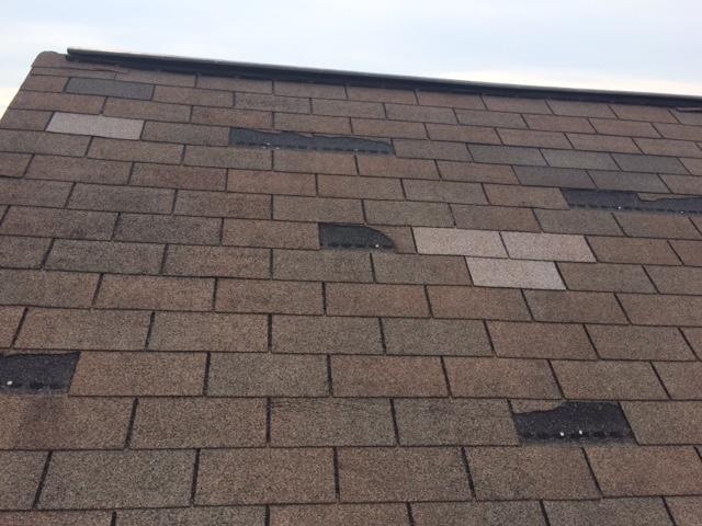 View of a roof with multiple missing shingles that appear to have been taken off due to wear and tear.