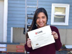 Golden Group Roofing team member holding a certificate for GAF CARE.