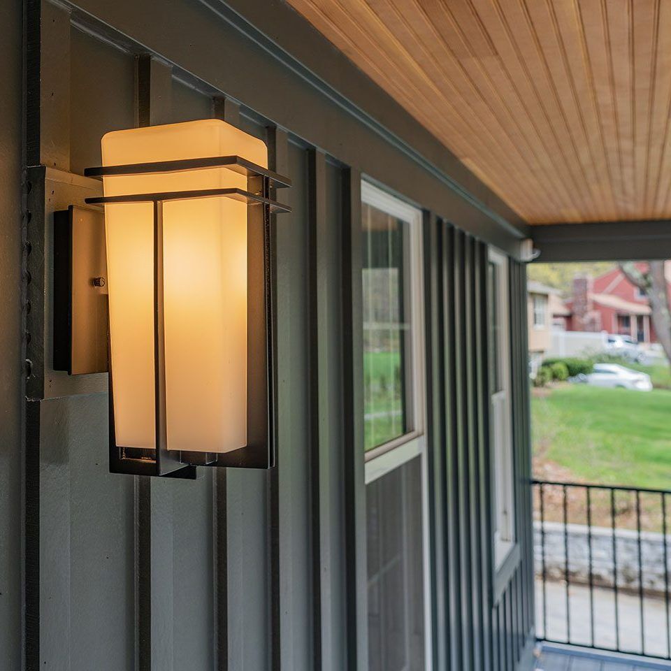 Side view of completed exterior siding on the porch of a home with an outside light