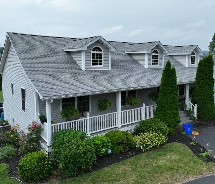 Aerial view of an Exterior Remodeling project with a new shingled roof, siding and deck with landscaping in front of the home.
