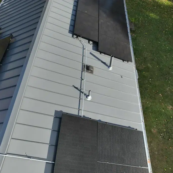 Solar Panel installed on a metal slanted roof surrounded by grass in Framingham, MA