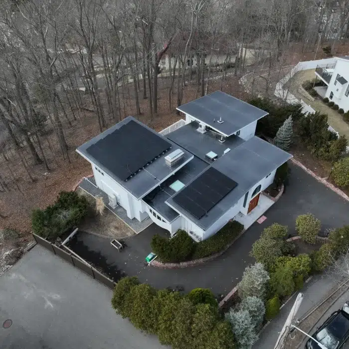 Aerial view of a residential home with multiple flat rooftop with Solar Panels installed in Newton, Massachusetts