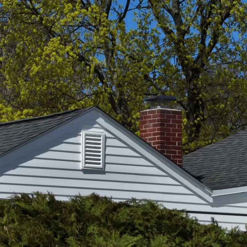 View of new residential Siding with an air vent and chimney in Marlborough, MA by Golden Group Roofing