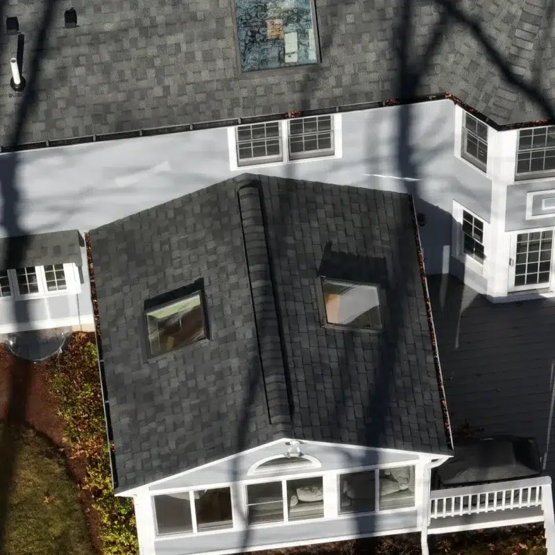 Aerial view of a Roofing Installation Service in Westborough, MA with a new shingled roof with multiple skylights.
