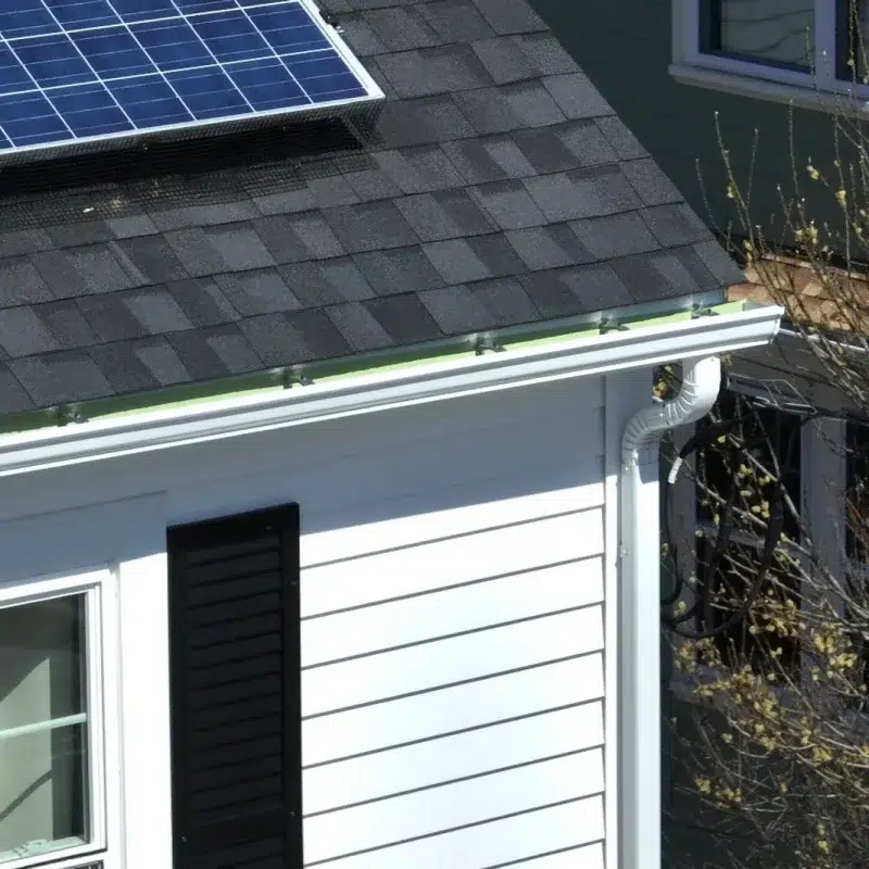 Aerial view of custom siding work completed in Natick, MA with solar panels on the slanted roof top