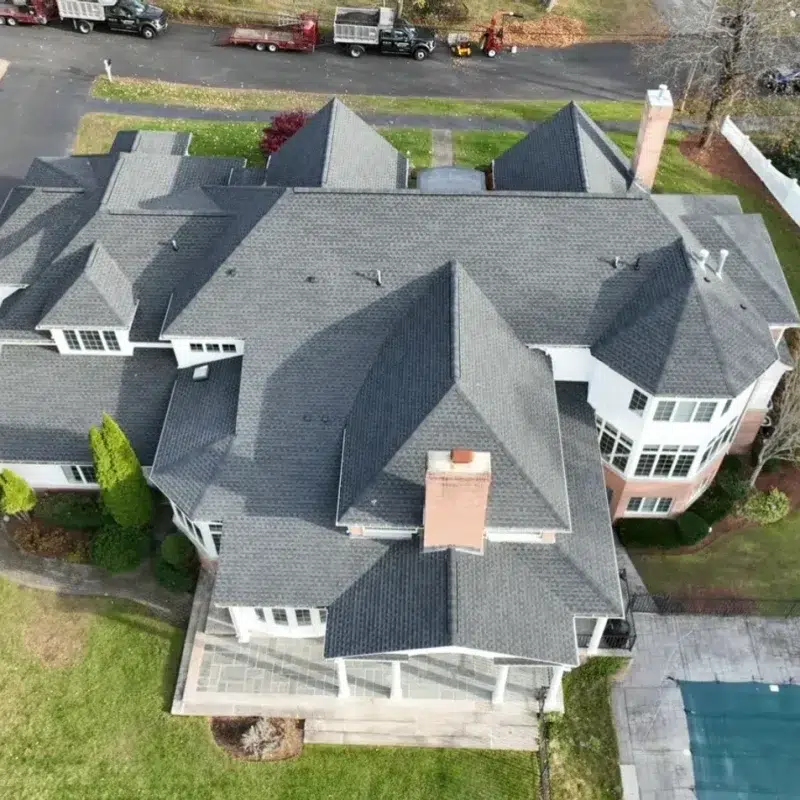 Large residential home with a new shingled grey roof on multiple roof tops in Concord, Massachusetts